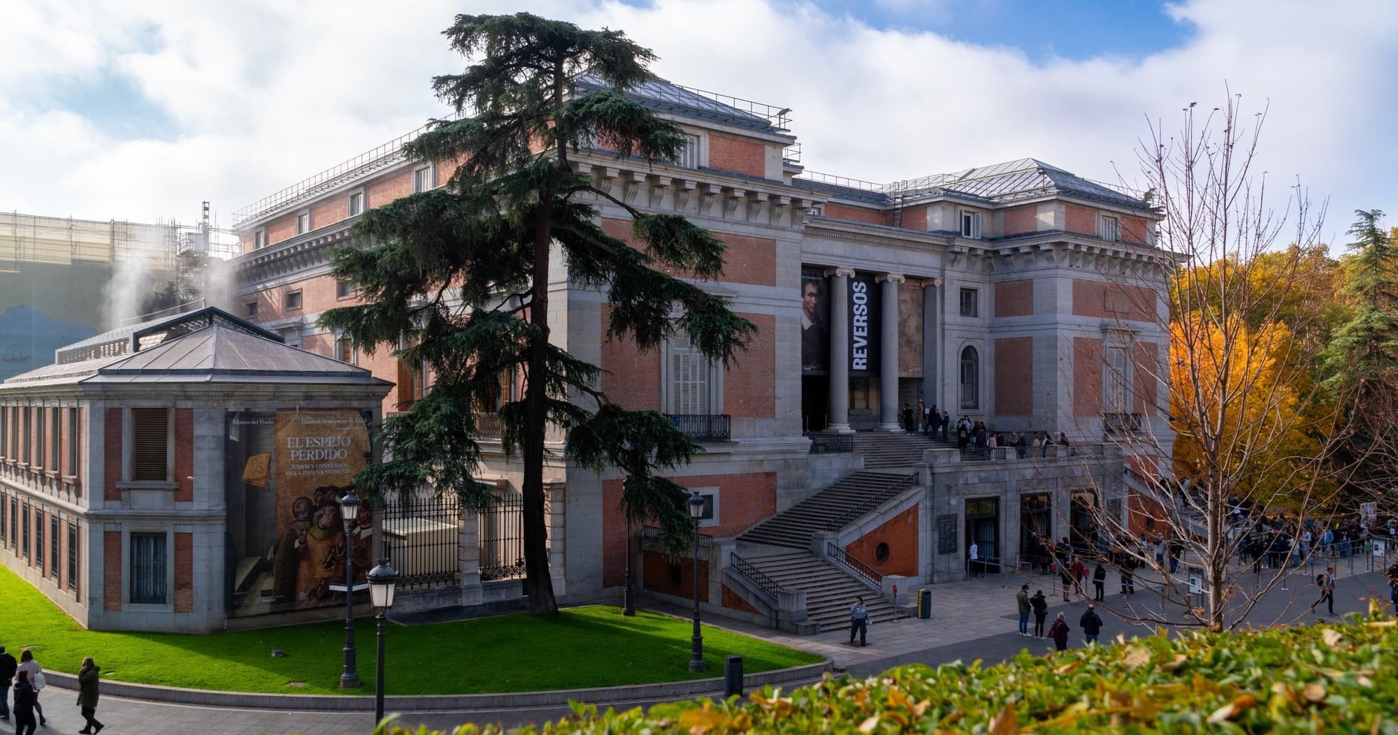 Historic Prado Museum facade with manicured lawn in Madrid center