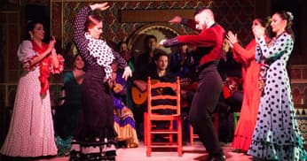 Flamenco troupe performing lively dance on intimate indoor Granada stage