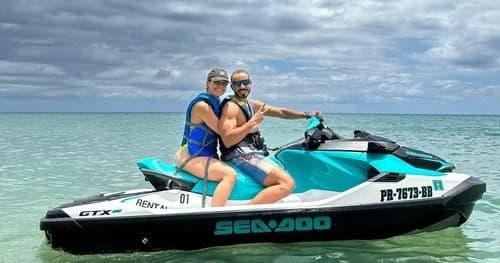 Couple riding a jet ski on turquoise tropical ocean waters