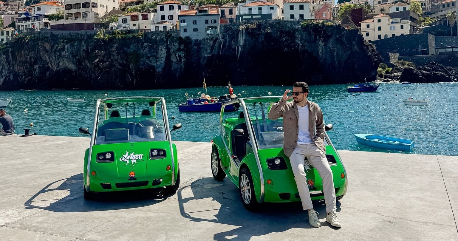 Two green tour buggies and guide at Funchal harbor, coastal tour