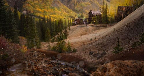 Autumn mountain valley with historic mine cabins for hiking