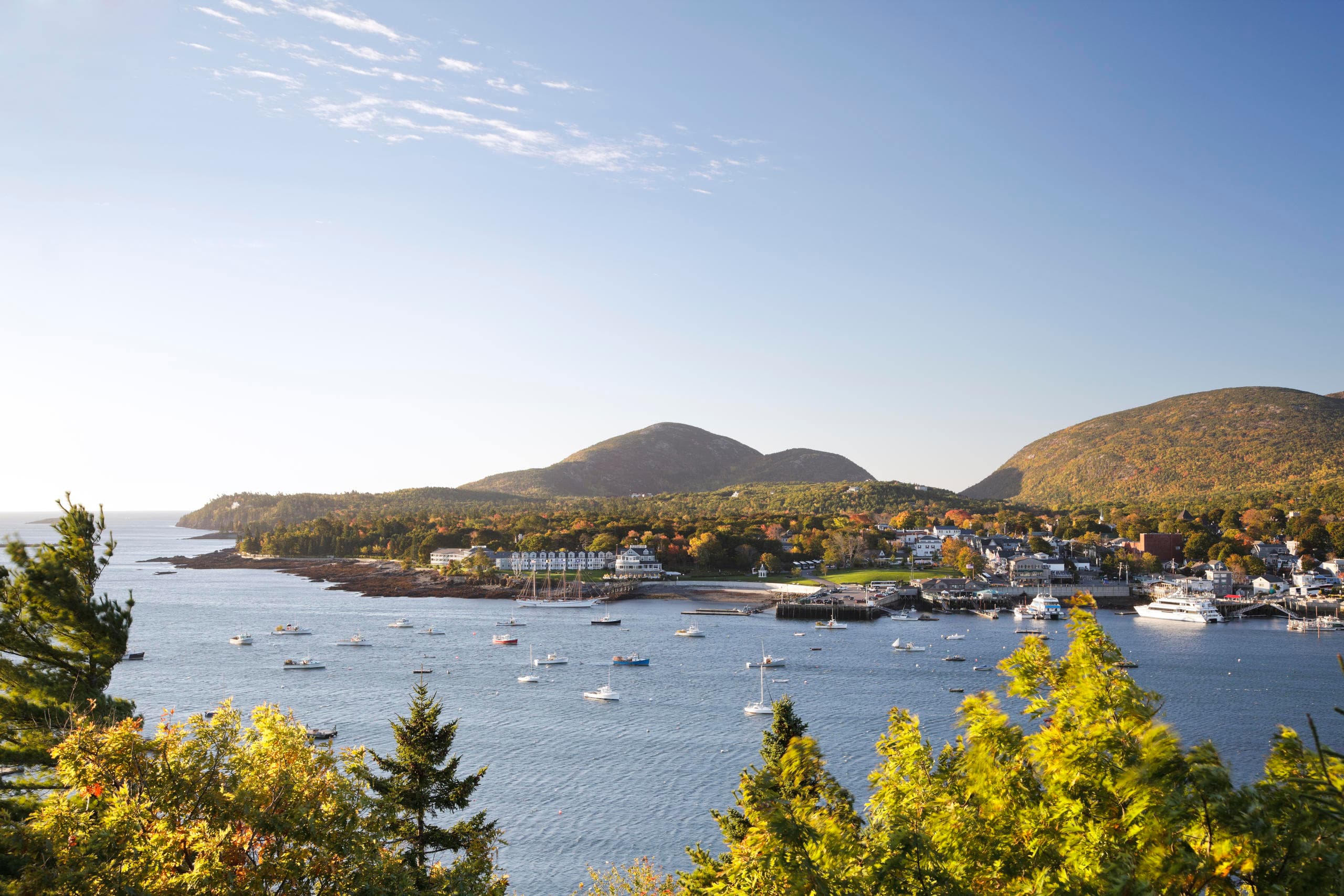 Panoramic coastal harbor with boats and island village view
