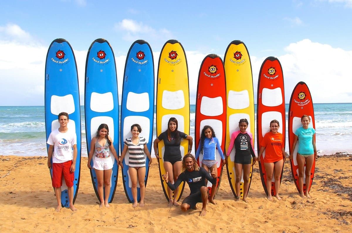 Colorful surfboards lined on sunny Puerto Rico beach with instructors