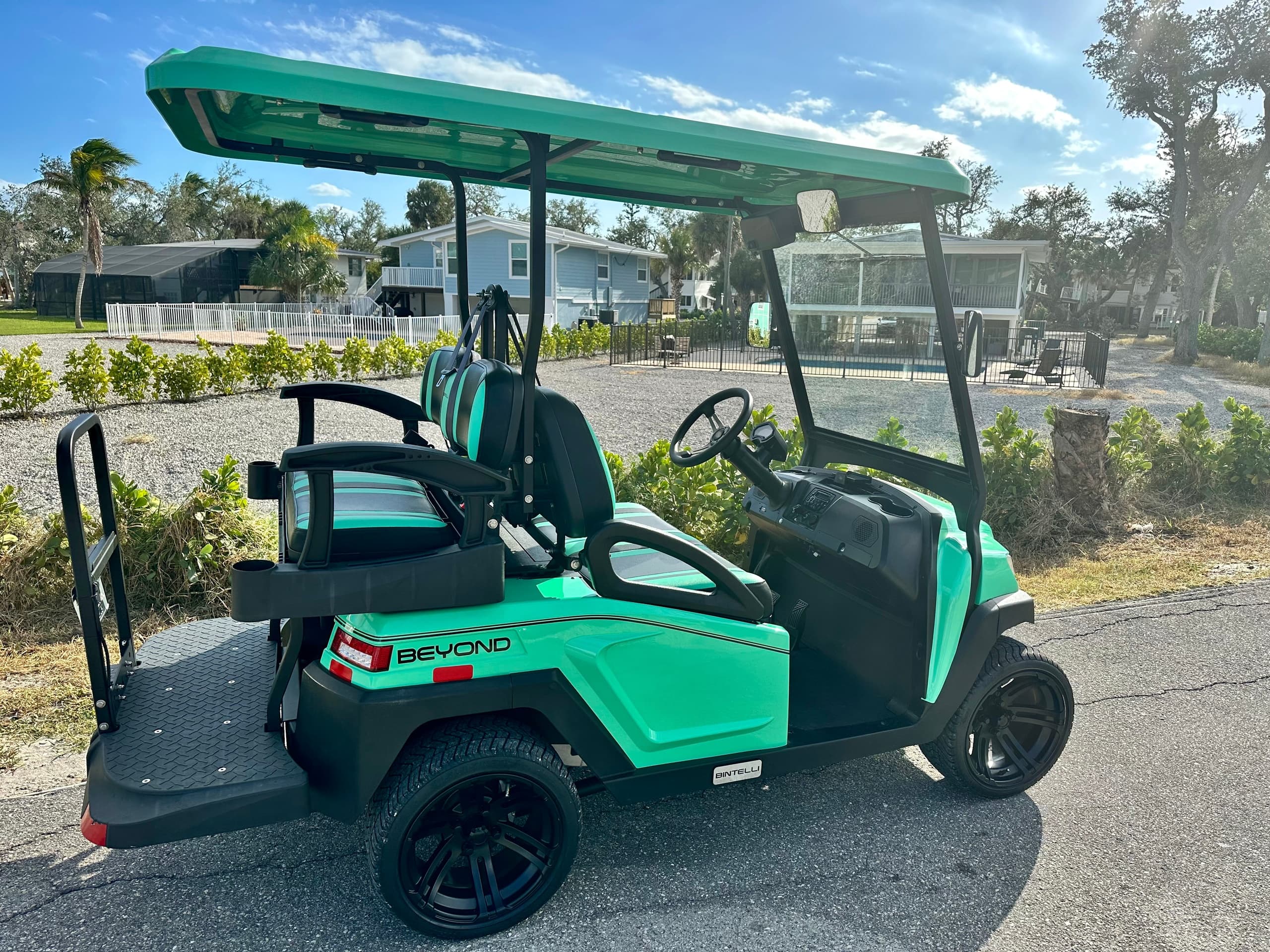 Teal golf cart ready for island tours on sunny coastal road