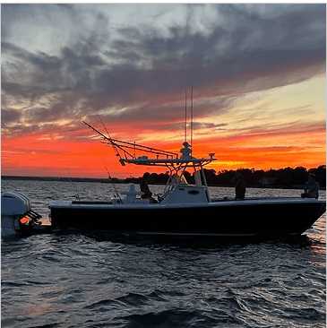 Fishing boat silhouette at Newport sunset, anglers preparing gear