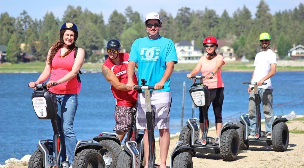 Group riding Segways along scenic mountain lake shoreline