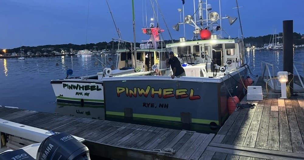 Charter tuna fishing boat Pinwheel docked at Rye Harbor dusk