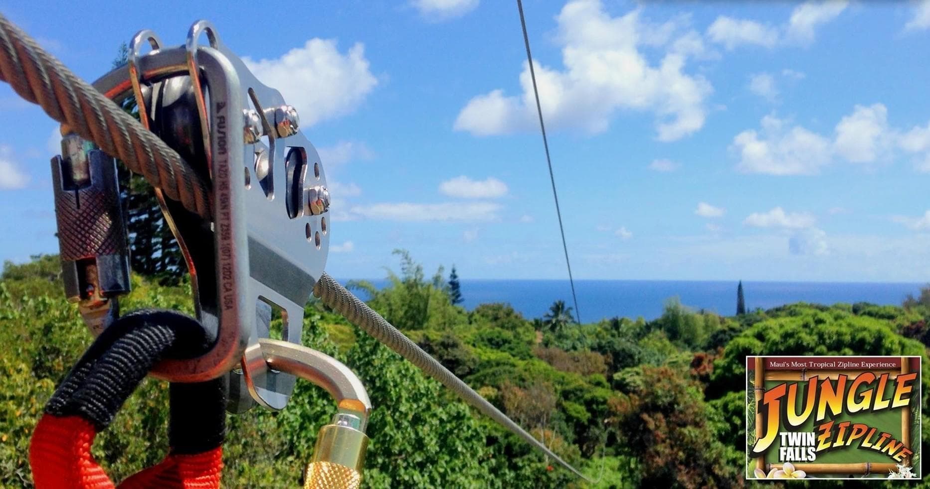 Zipline pulley over coastal jungle canopy with ocean vista
