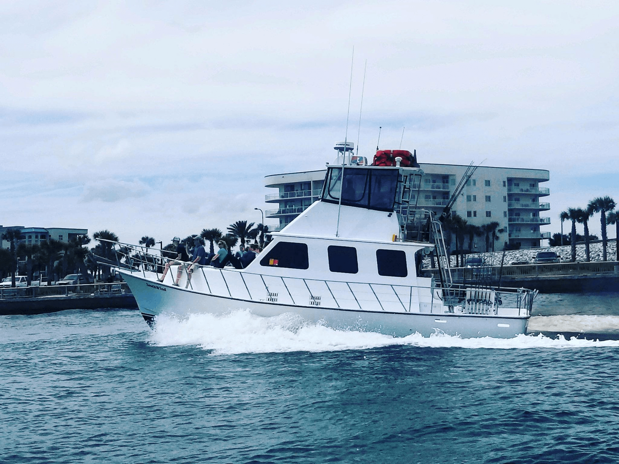 Large sportfishing yacht speeding past shoreline near Orange Beach