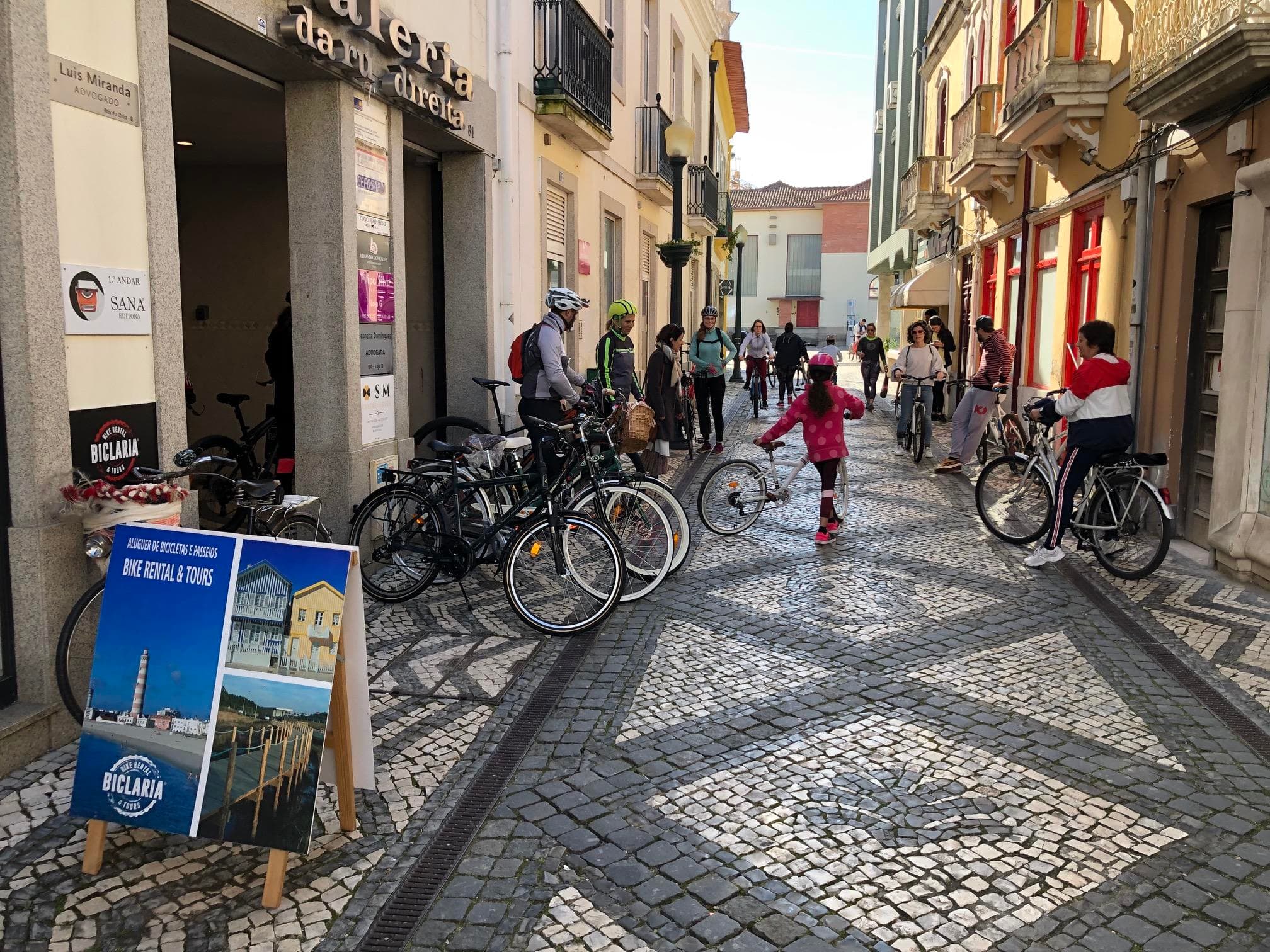 Busy cobblestone street bike rental scene in historic town