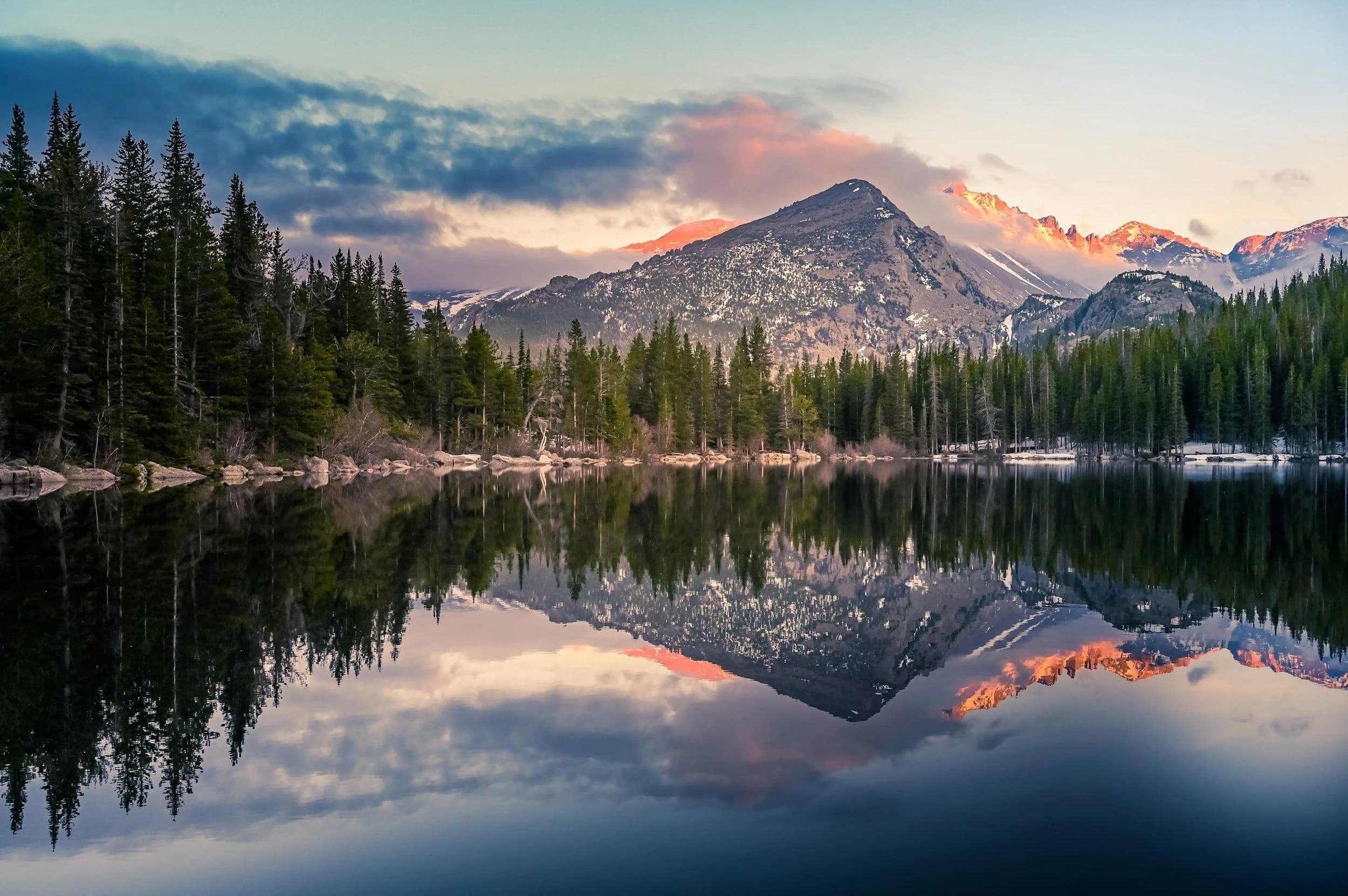 Sunrise over mirrored mountain lake, calm alpine reflection