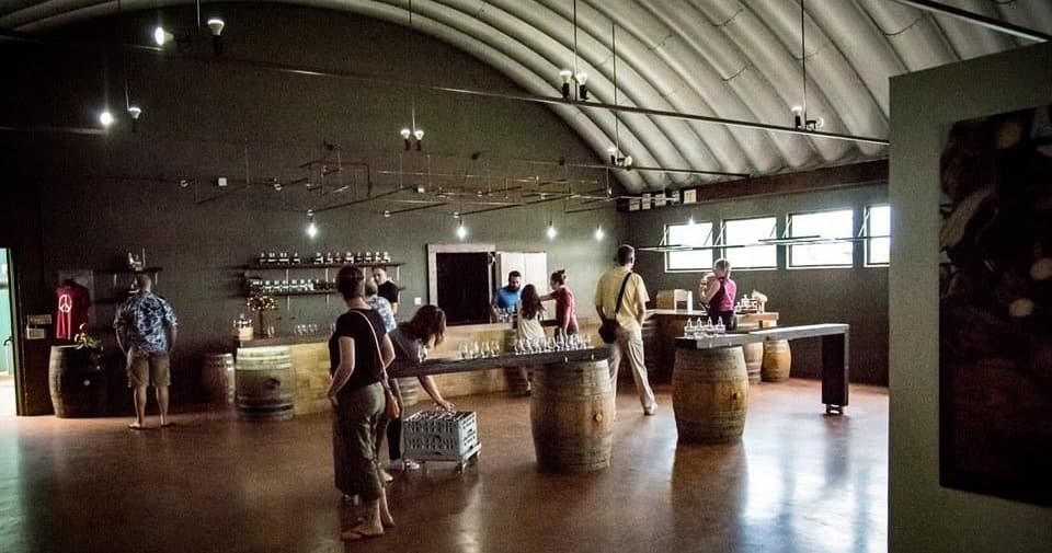 Distillery tasting room with wooden barrels and visitors