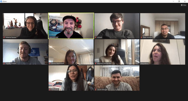 Remote team video conference on Zoom with mixed home backdrops