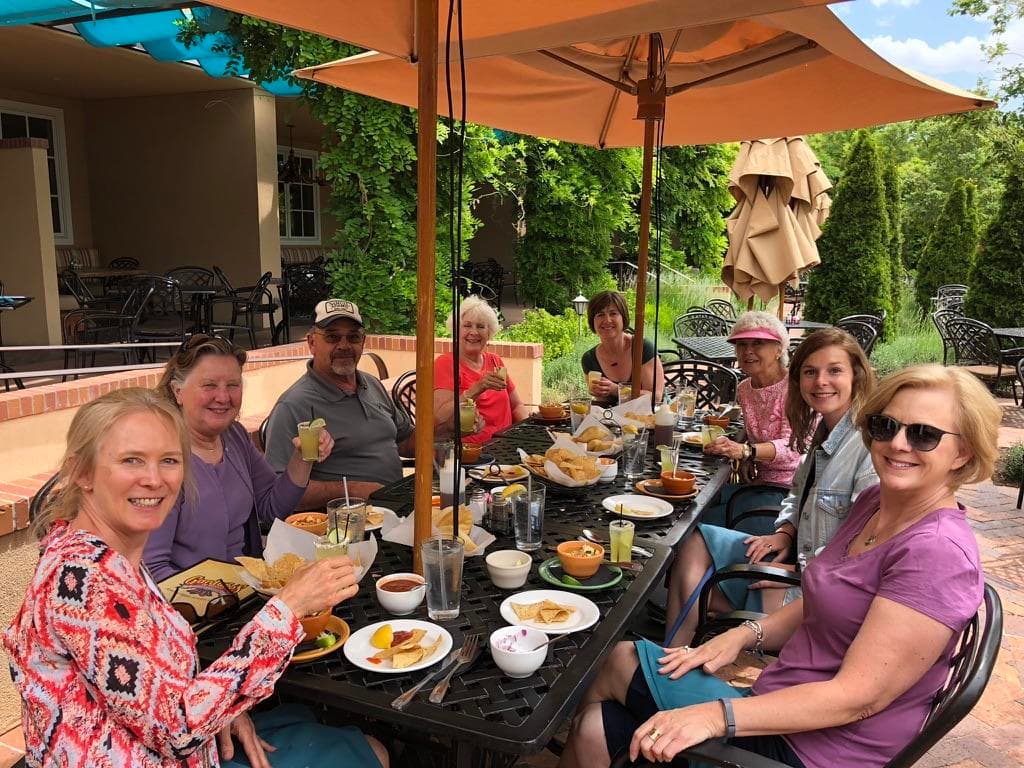 Patio food tour participants eating under umbrellas on terrace