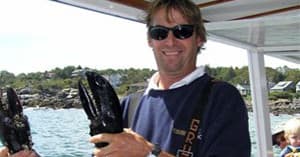 Fisherman displaying caught lobsters aboard charter fishing boat