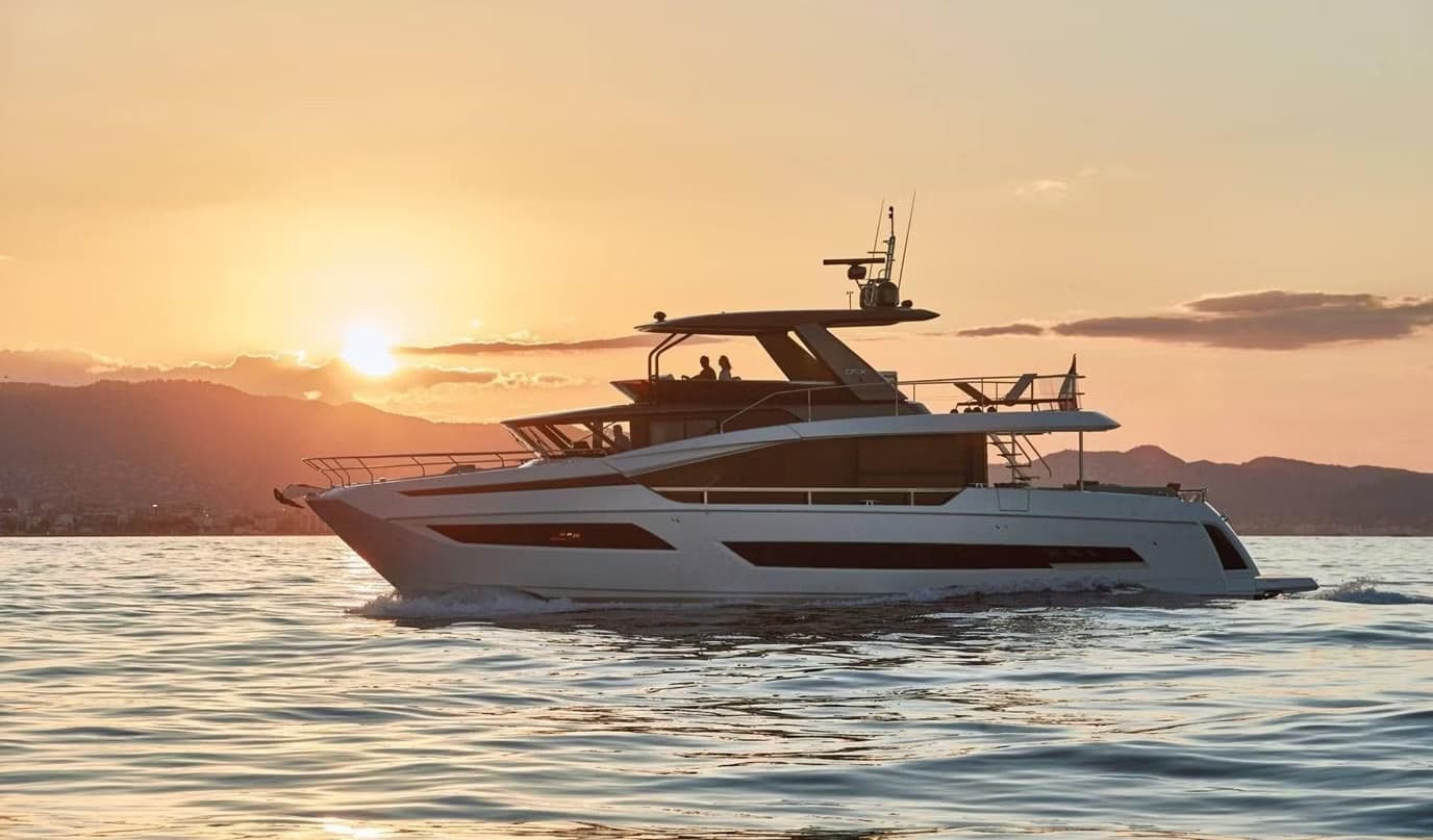 Luxury yacht silhouetted at sunset on calm coastal waters