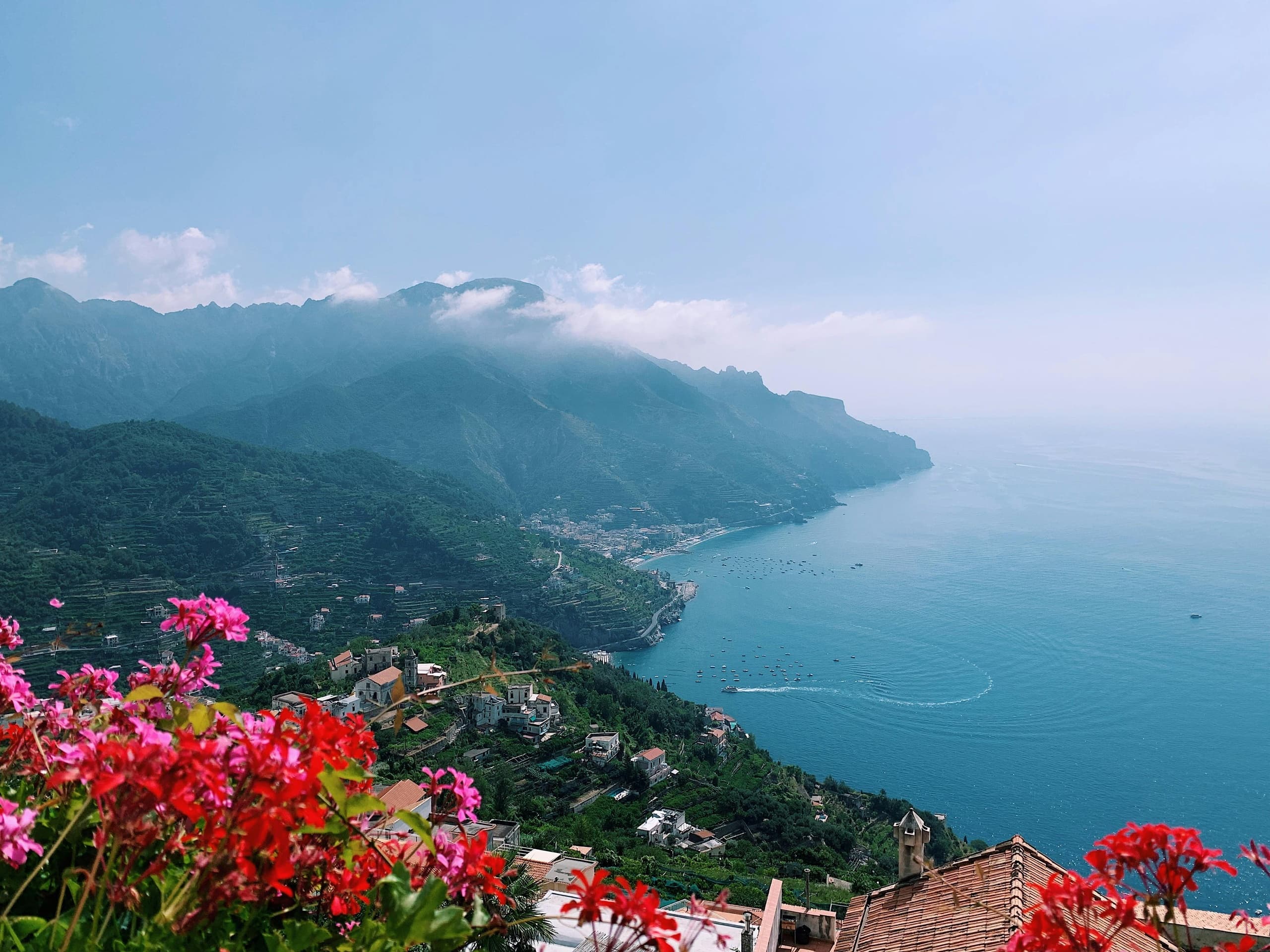 Clifftop panoramic view of Amalfi coastline with vibrant flowers