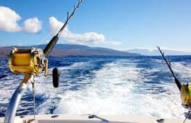 Sportfishing rods trailing in deep blue ocean wake on boat