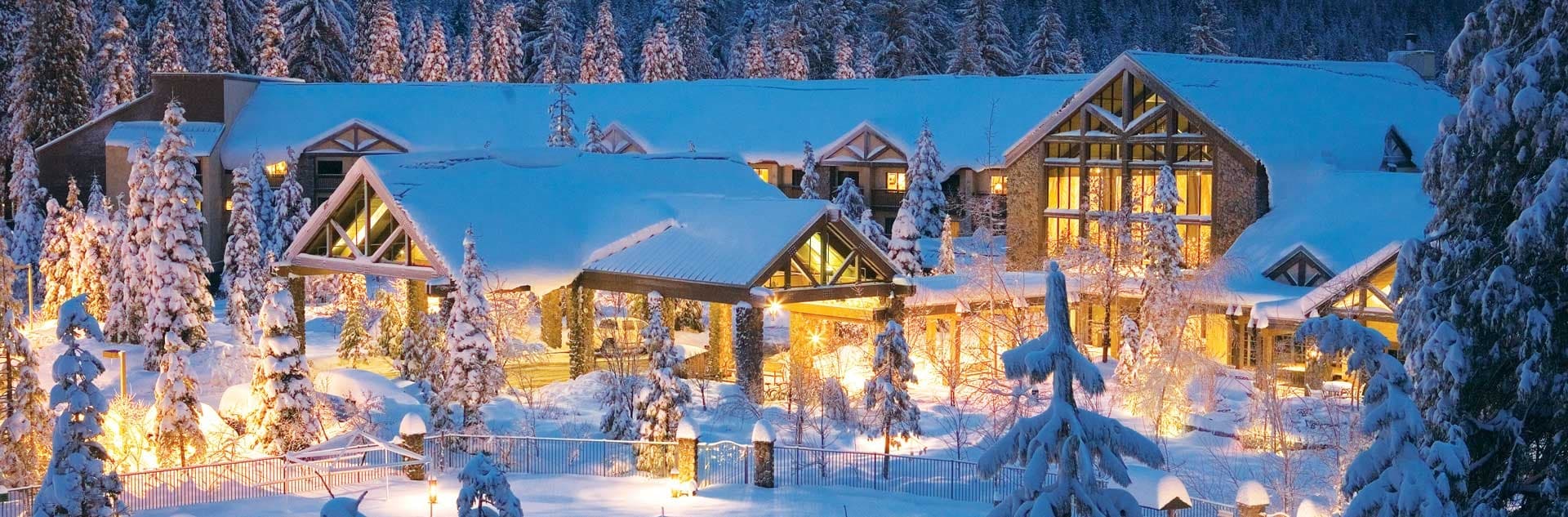 Snowy mountain resort village lit at twilight, alpine ambiance