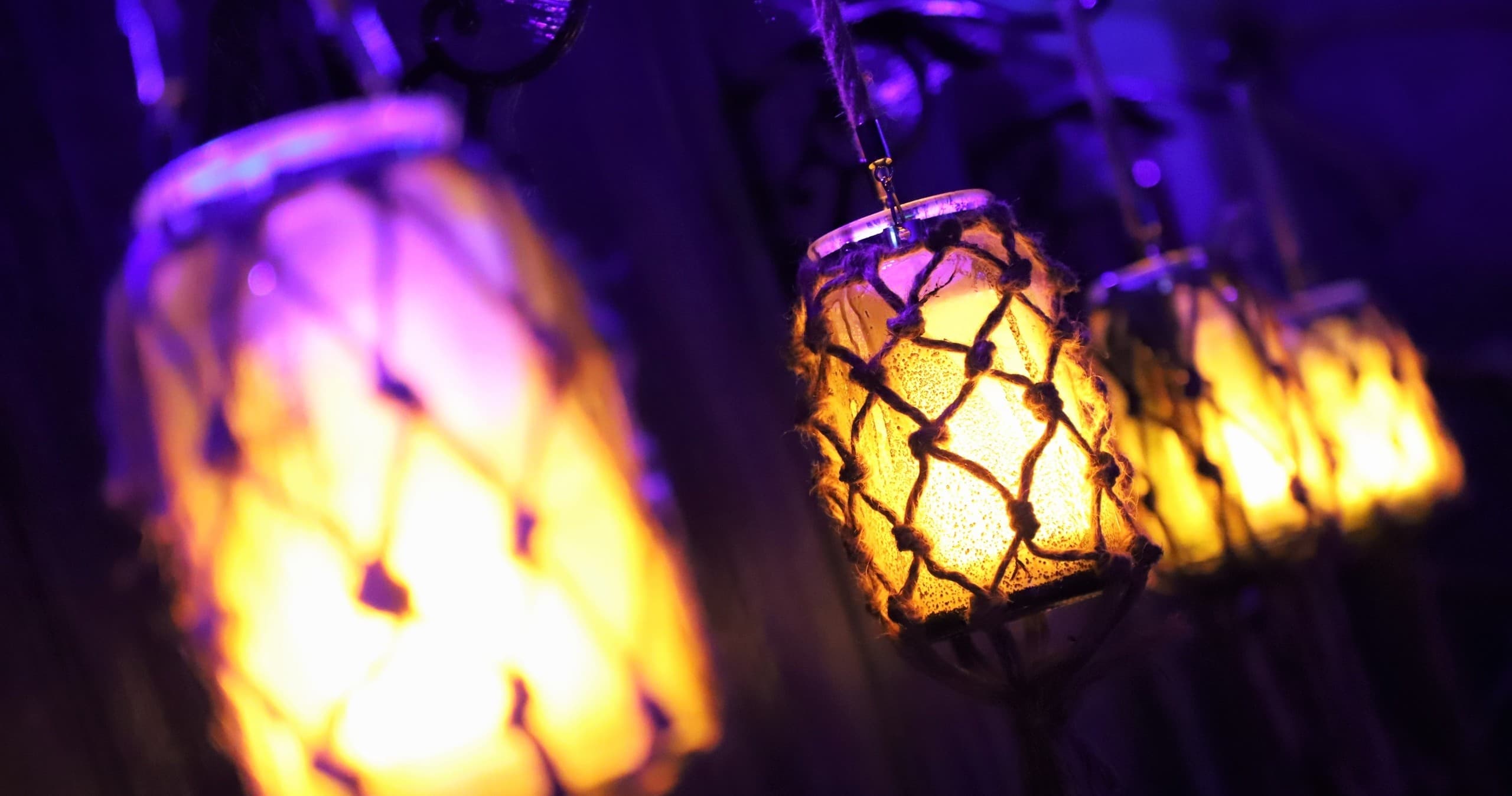 Hanging lanterns casting warm glow in moody game room scene