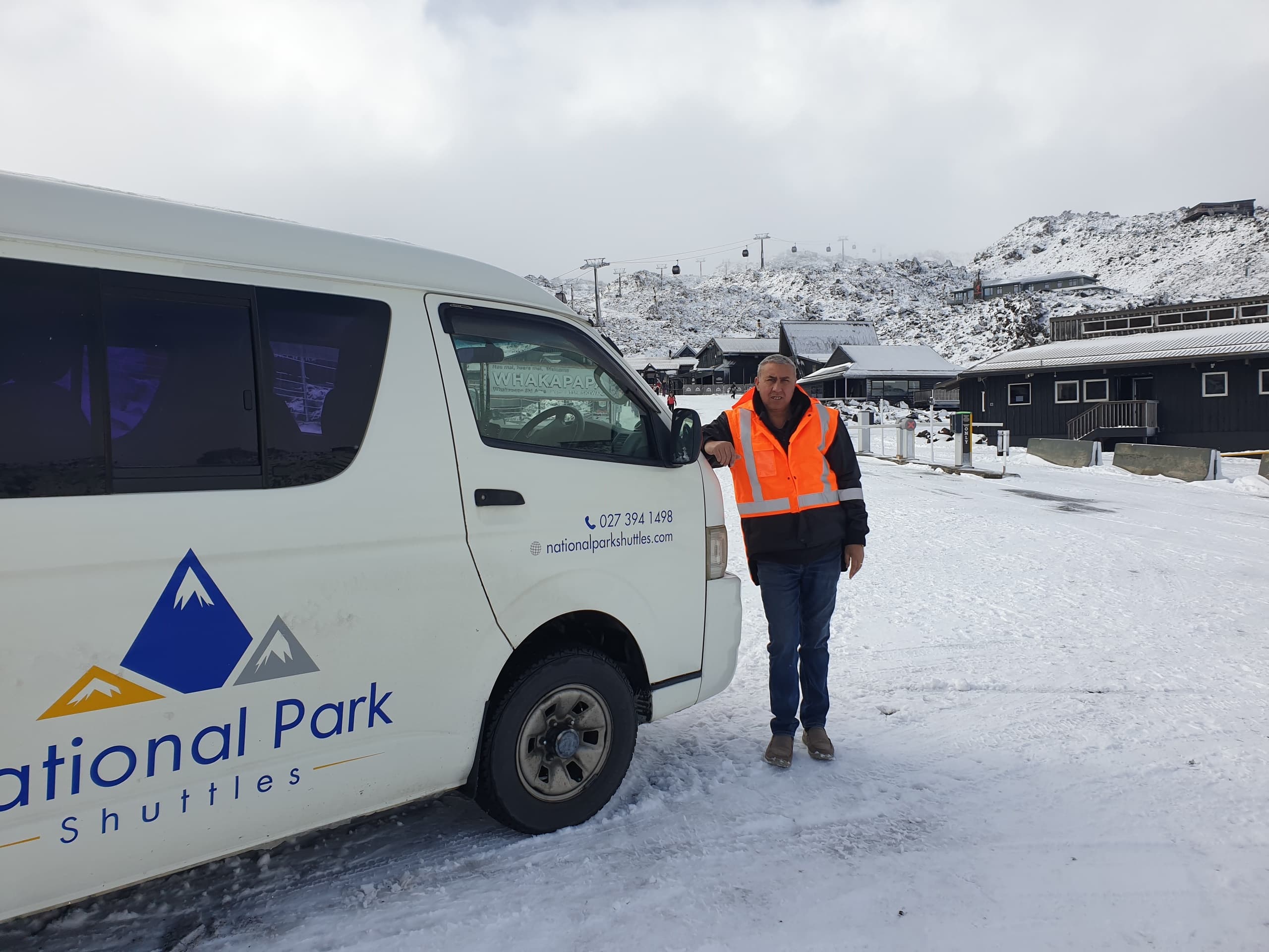 Minivan shuttle in snowy national park base with driver posing