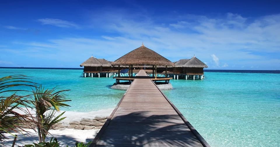 Overwater bungalows and wooden pier in turquoise tropical lagoon