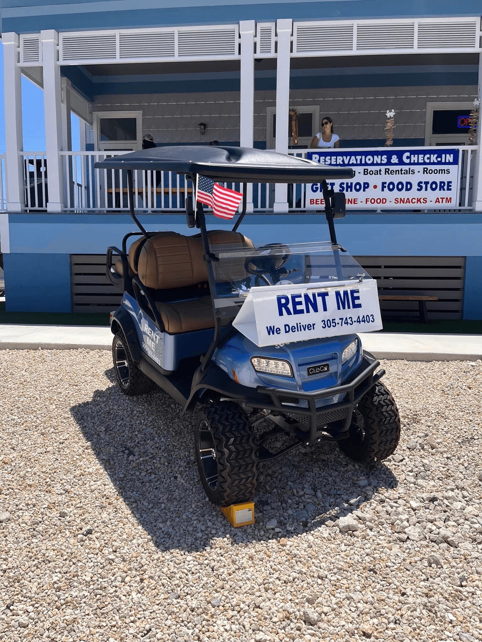 Front view rental golf cart with RENT ME sign at storefront