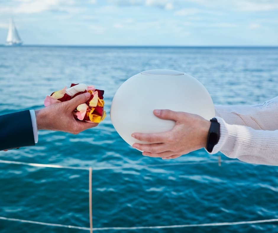 Hands exchanging buoy on deck against open ocean backdrop