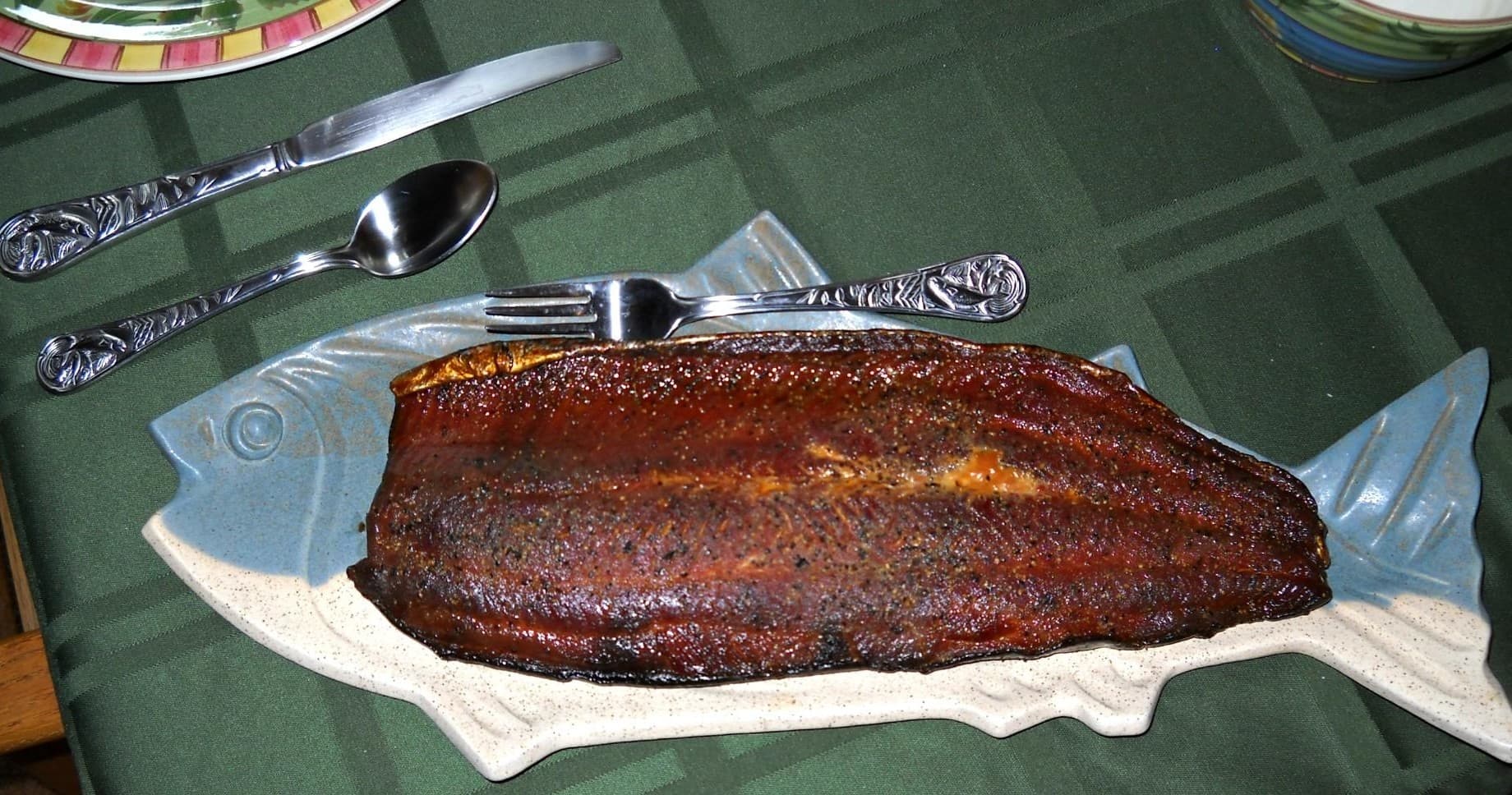 Smoked salmon fillet served on fish platter at table