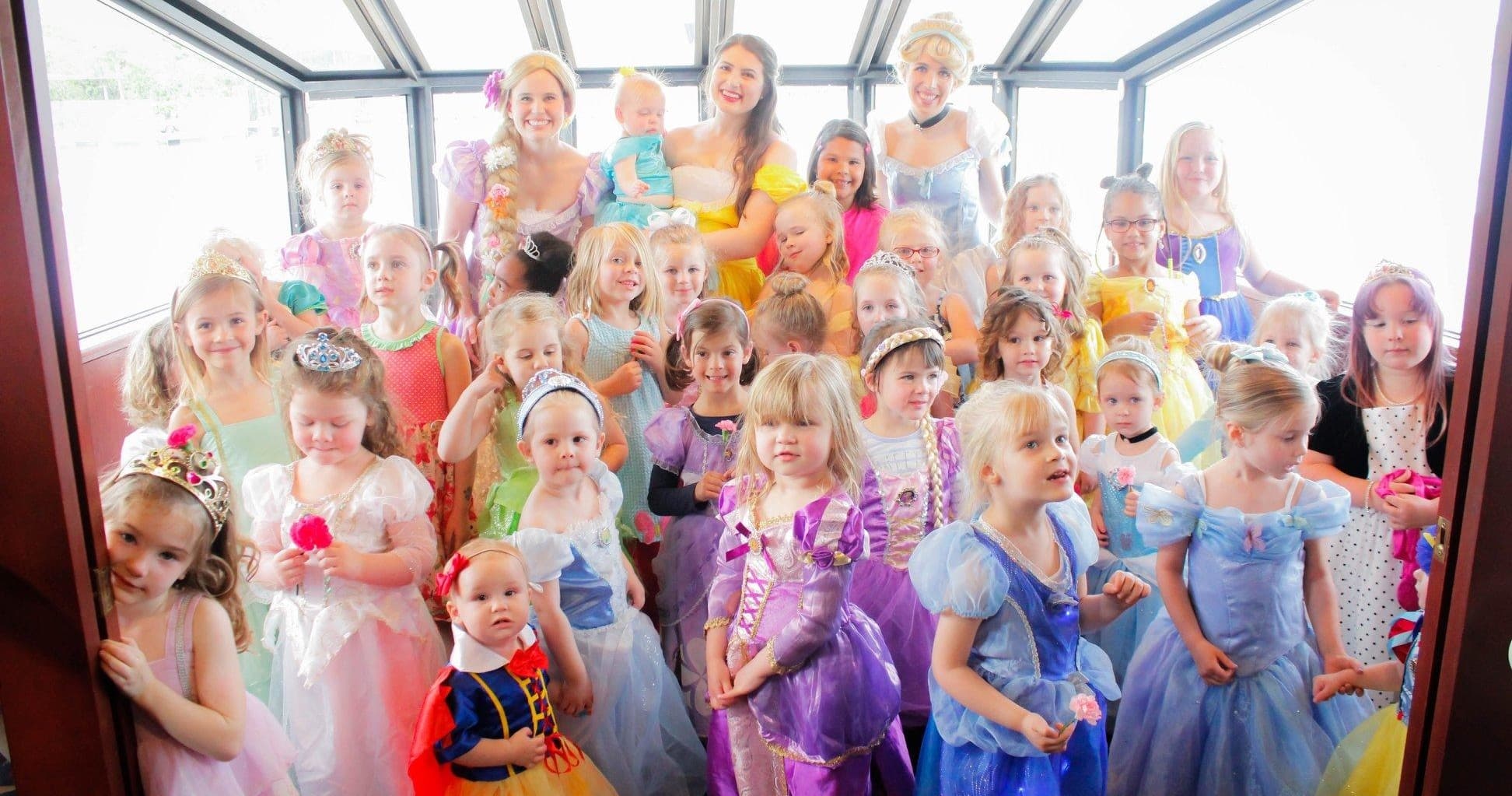 Children in princess costumes at indoor Knoxville party posing together