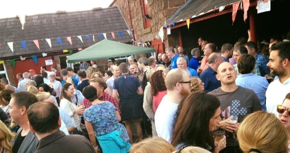 Festival crowd gathered at outdoor beer event under bunting