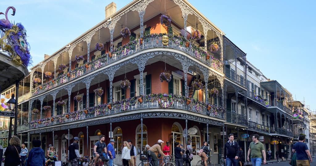 Crowds enjoying balcony-lined French Quarter street festival outdoors