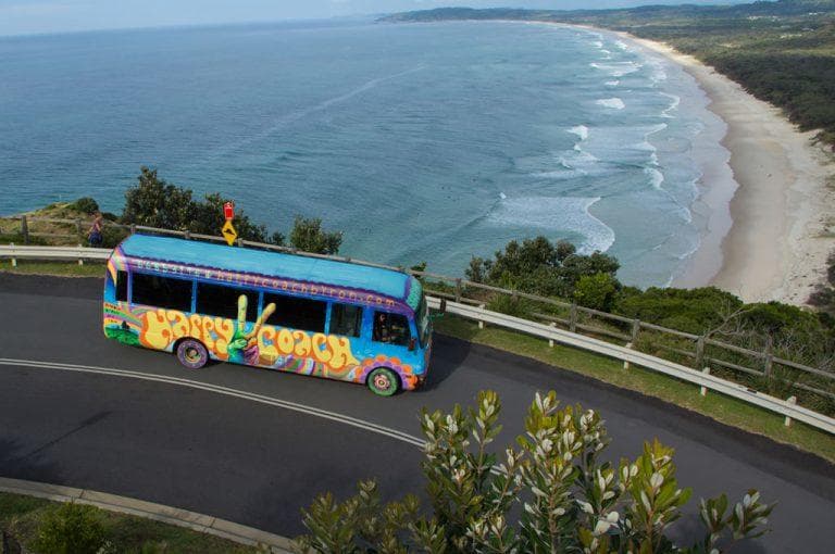 Coastal scenic drive with colorful tour bus along ocean cliff