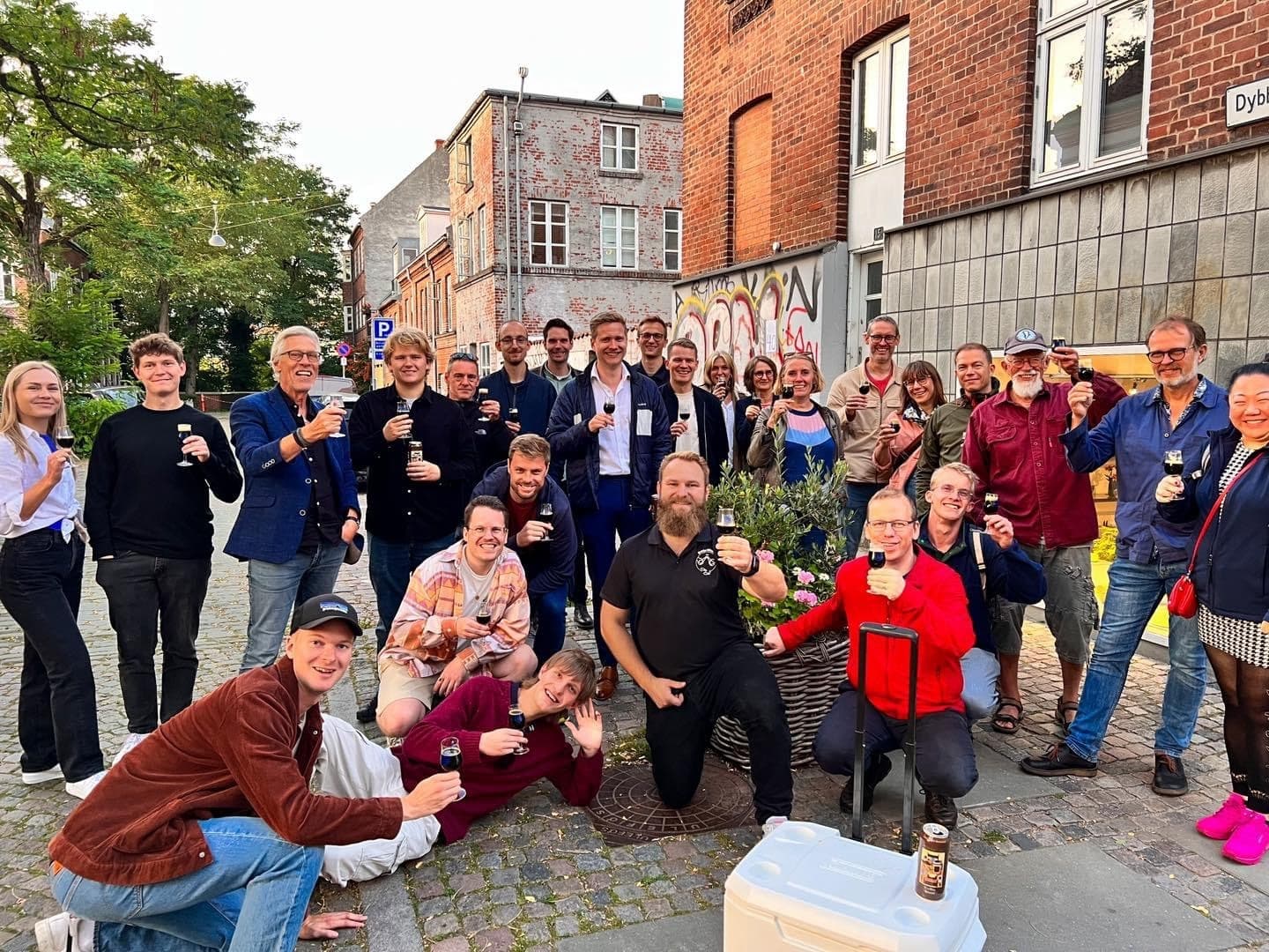 Large group celebrating on cobblestone street during guided beer walk