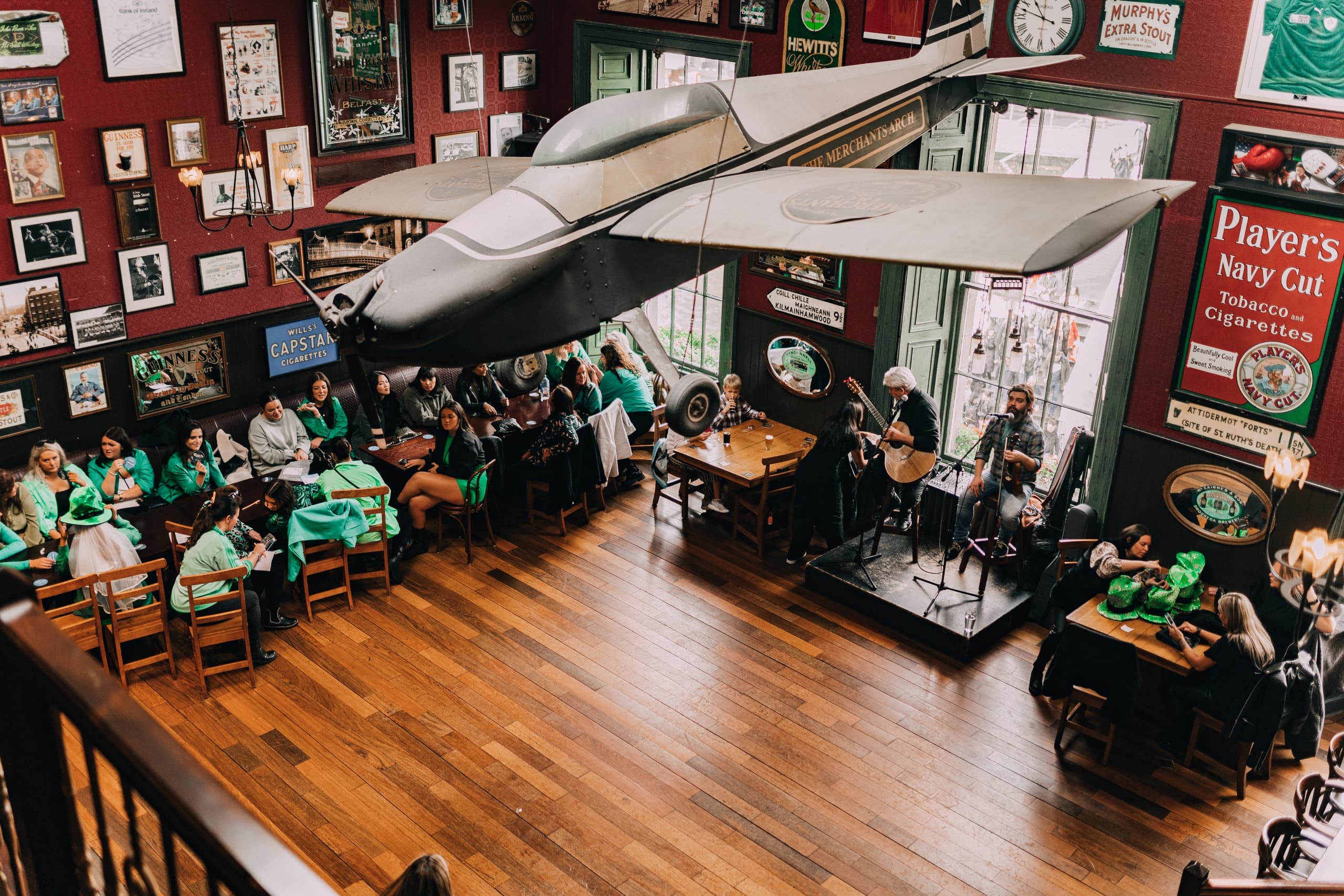 Wide pub interior showing stage and audience at Irish event