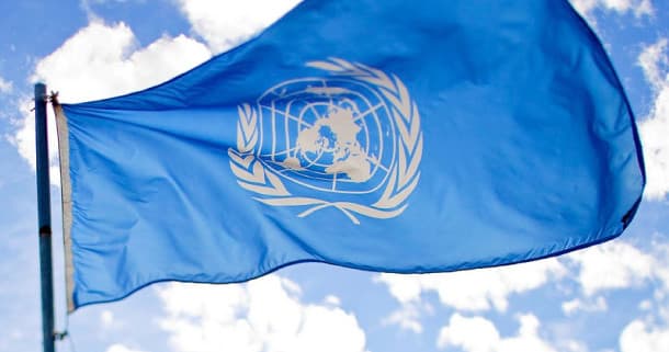 United Nations flag waving against blue sky at UN plaza