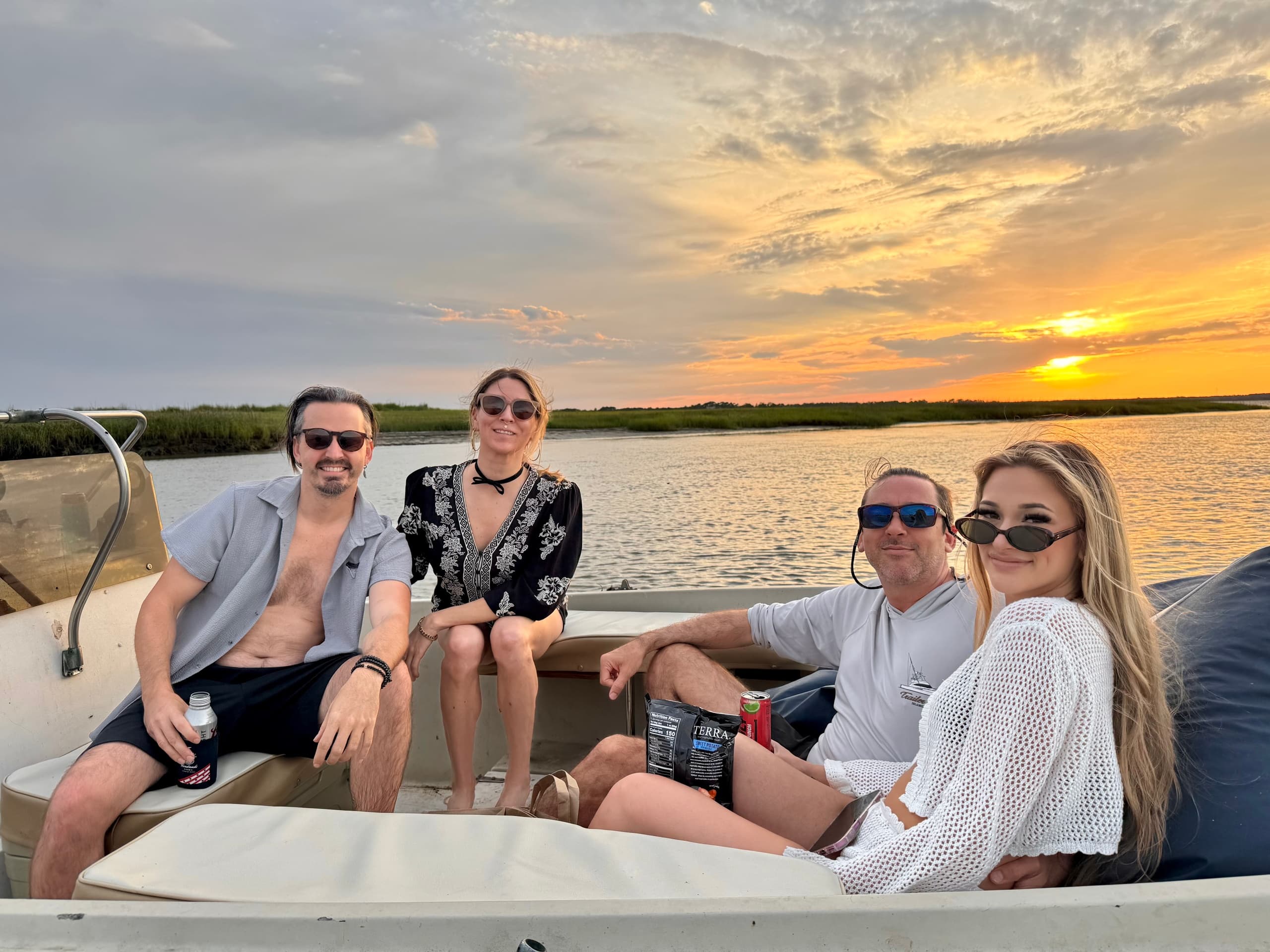 Friends enjoying sunset boat tour through Charleston tidal creeks