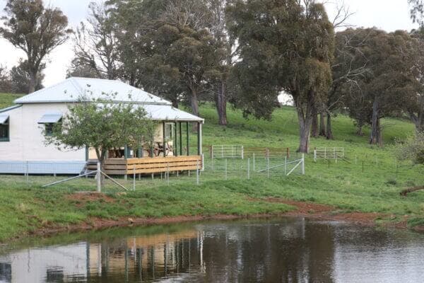 Rural cottage by reflective pond in pastoral NSW farm stay