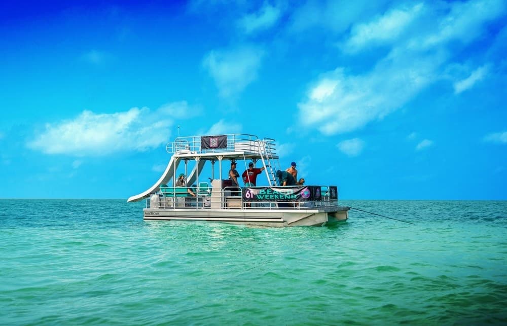 Pontoon boat with slide on turquoise ocean, beach cruise