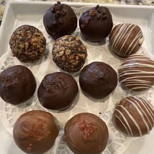 Assorted gourmet chocolate truffles on doily tray for tasting