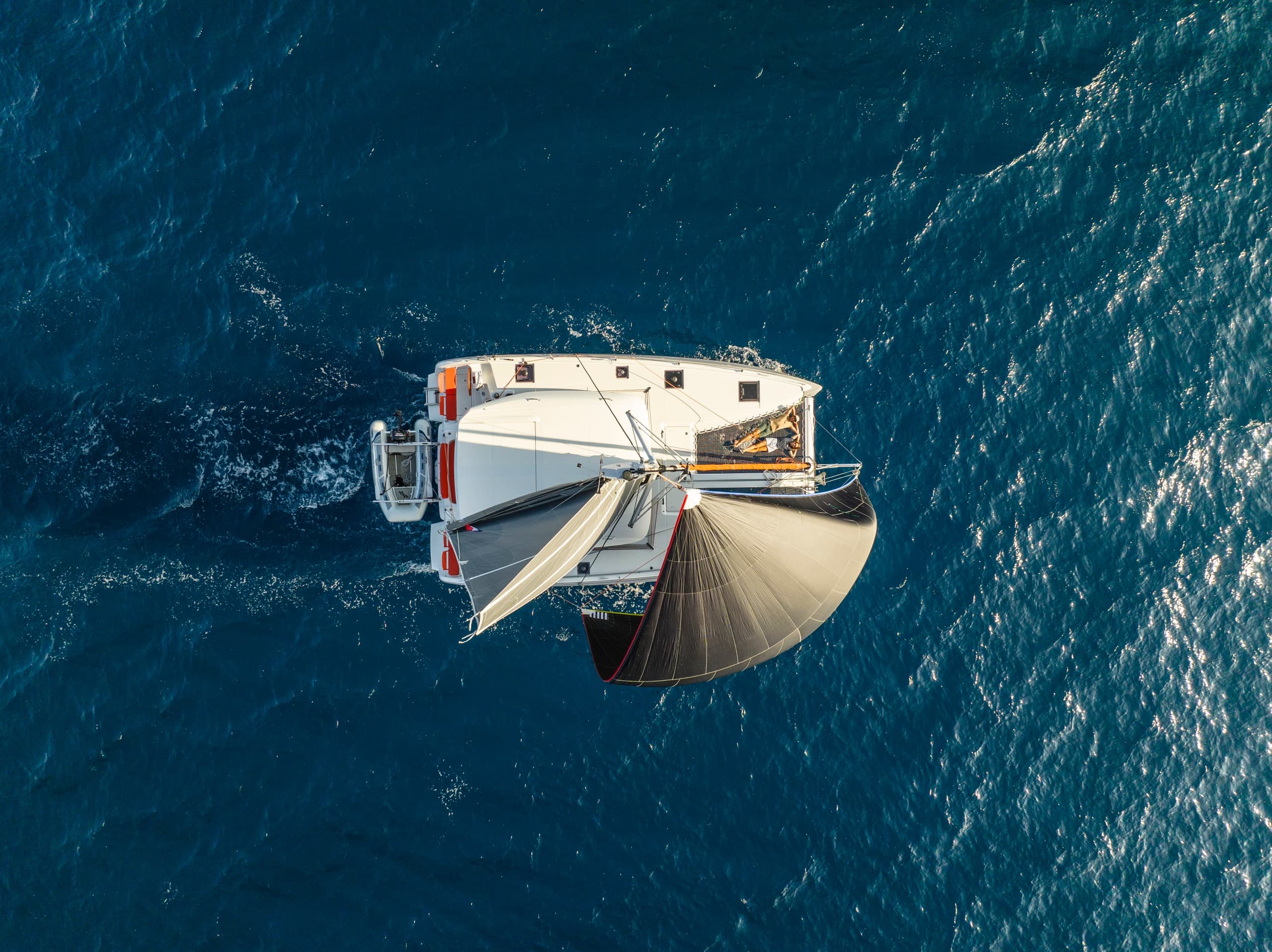 Aerial view of catamaran sailing over deep blue ocean water