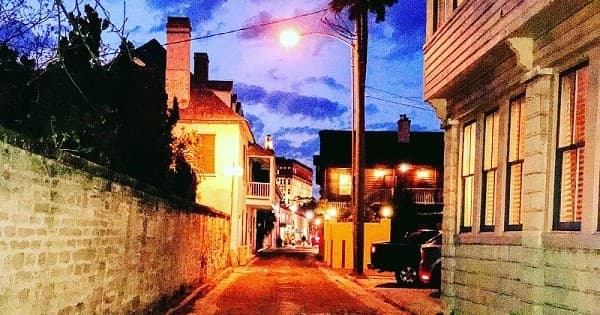 Colorful historic coastal alley at dusk, walking tour scene