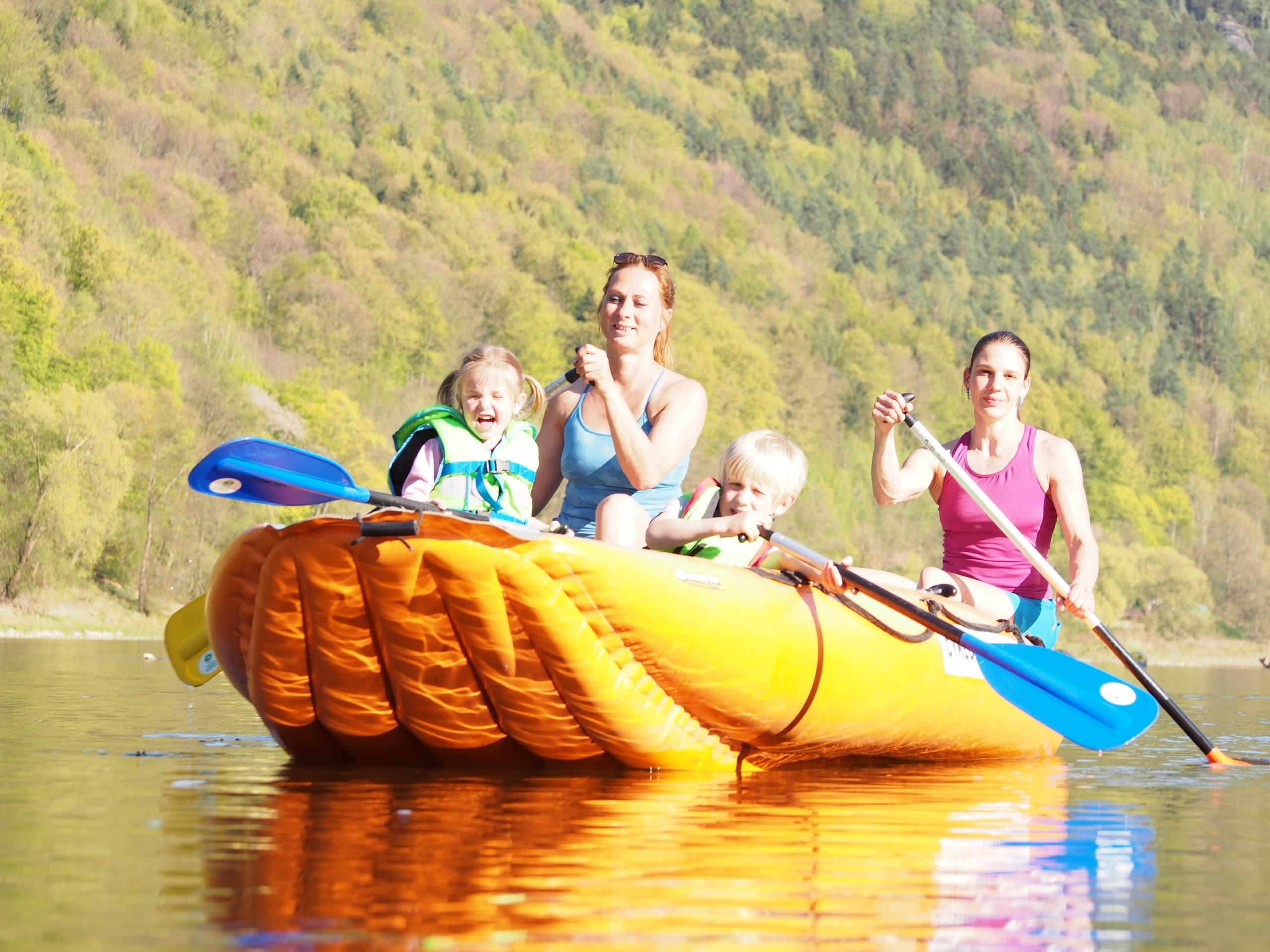 Family rafting on gentle river with castle and town skyline