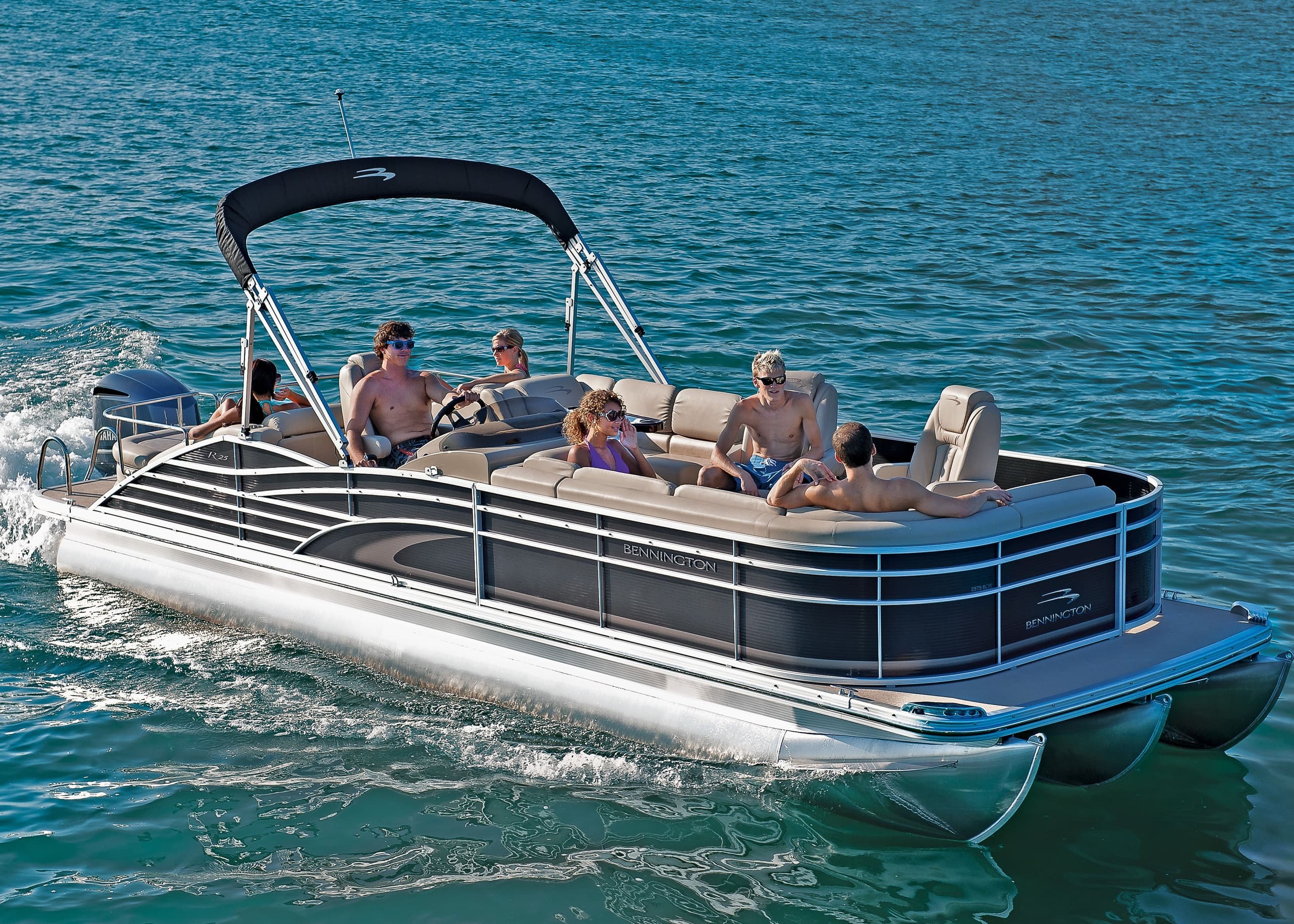 Pontoon boat cruising on turquoise sea with passengers aboard