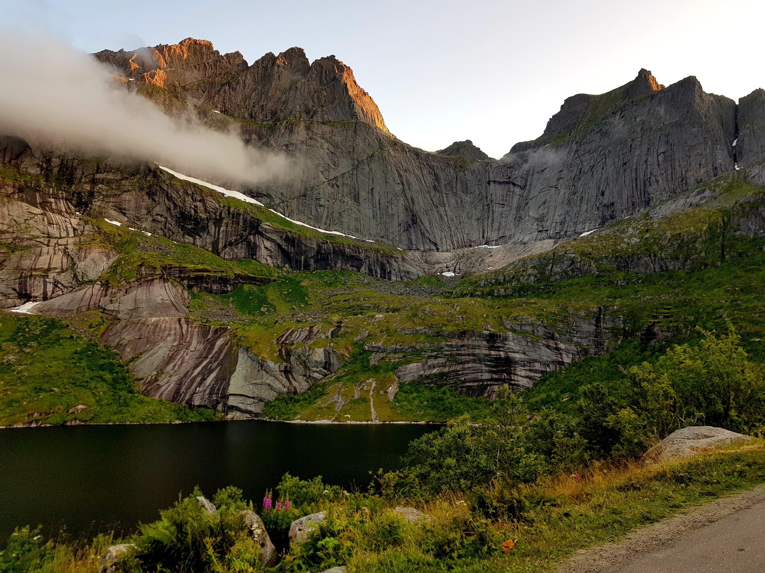 Emerald alpine lake beneath dramatic mountain cliffs in Norway