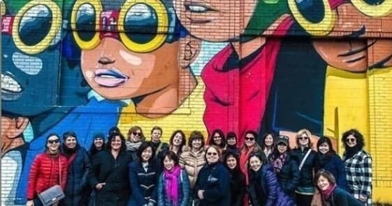 Group on guided bike tour in front of colorful Detroit mural
