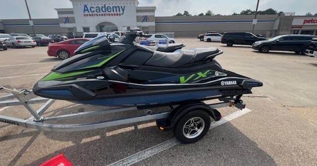 Pair of Yamaha VX jet skis on trailer in parking lot