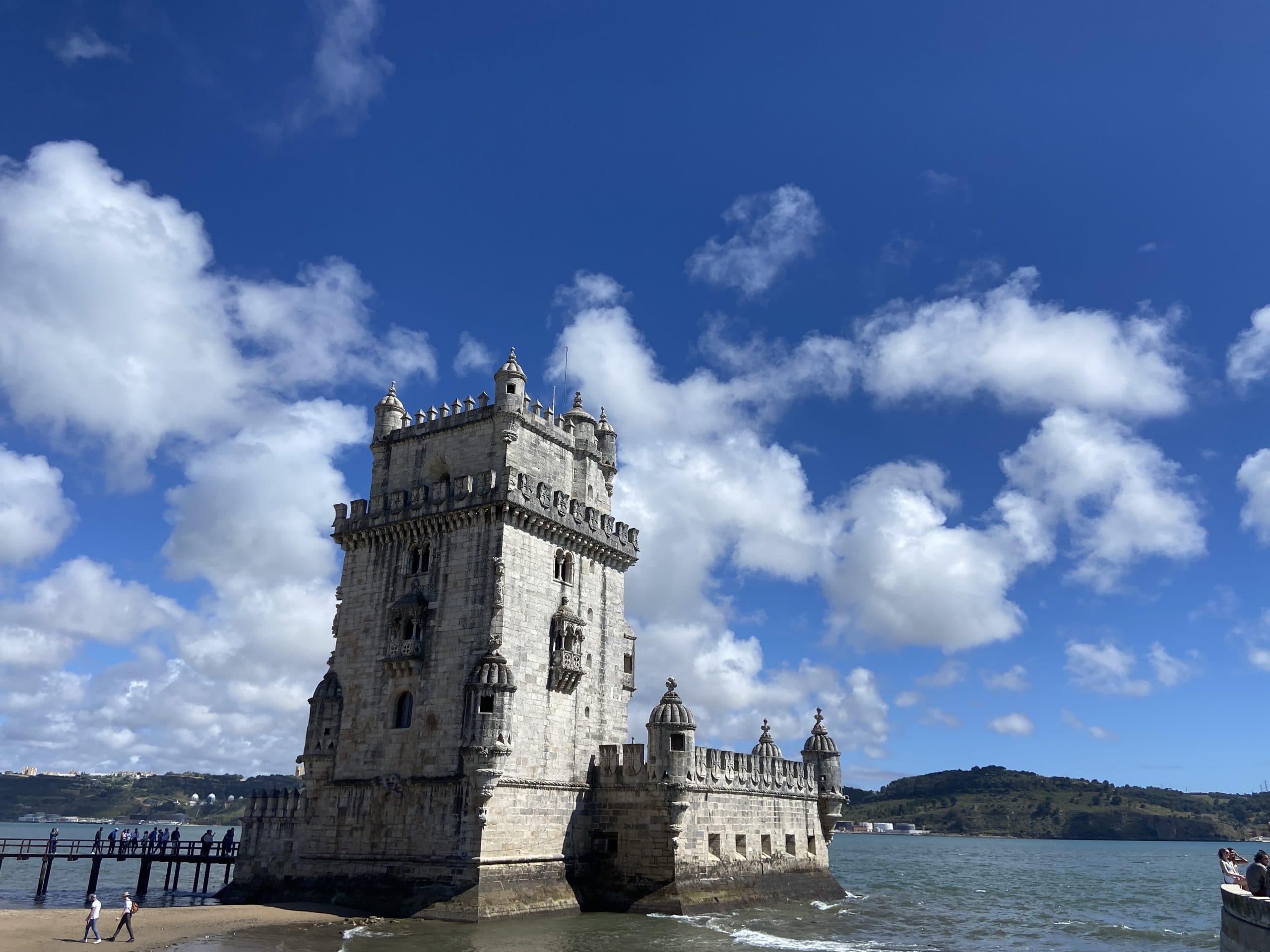 Historic Belém Tower on Tagus River under blue sky, Lisbon landmark