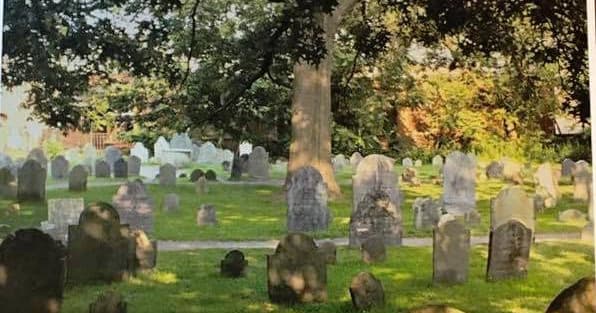 Historic Salem cemetery with aged gravestones under oak trees