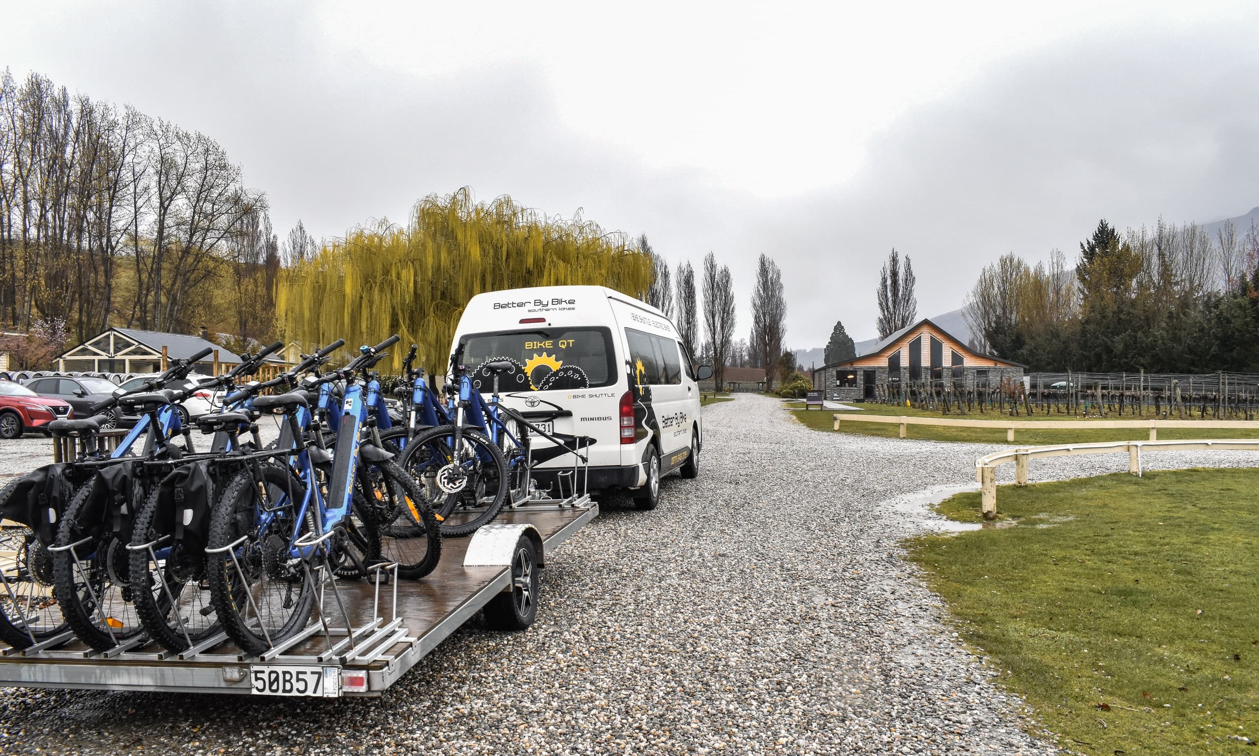 Shuttle van loading bikes on trailer at rural New Zealand trailhead